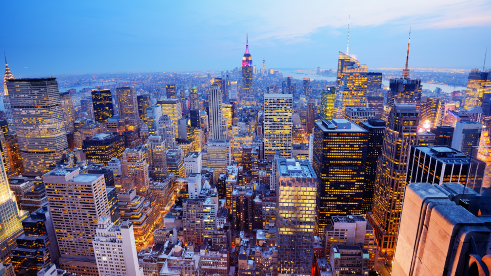 Aerial view of New York City at night with Empire State Building in background. 