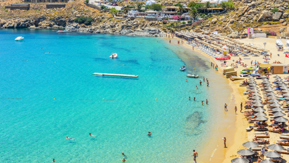 Aerial view of cabanas and beach goers at Famous Paradise Beach - Mykonos, Greece 