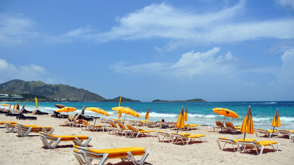 Orient Bay Beach St. Martin with yellow sunbeds and umbrellas 