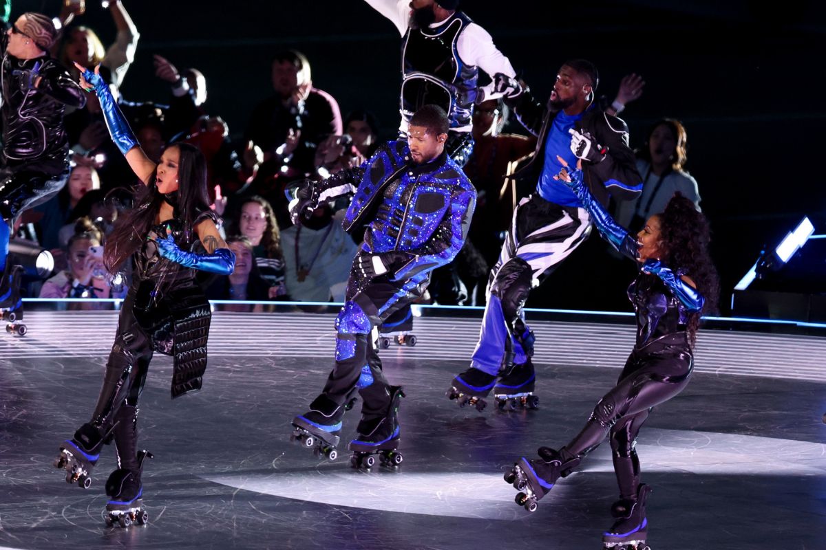 Usher and dancers roller skating on stage