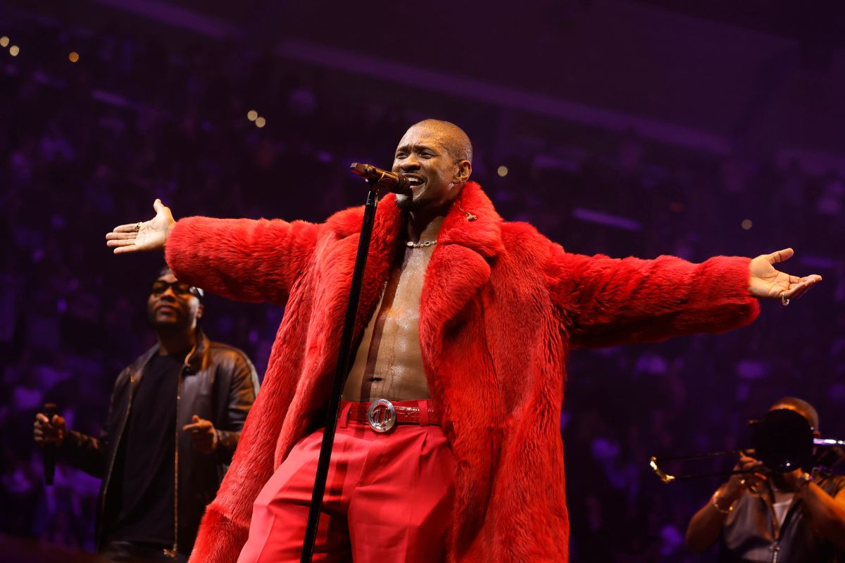 Usher in red fur coat on stage performing