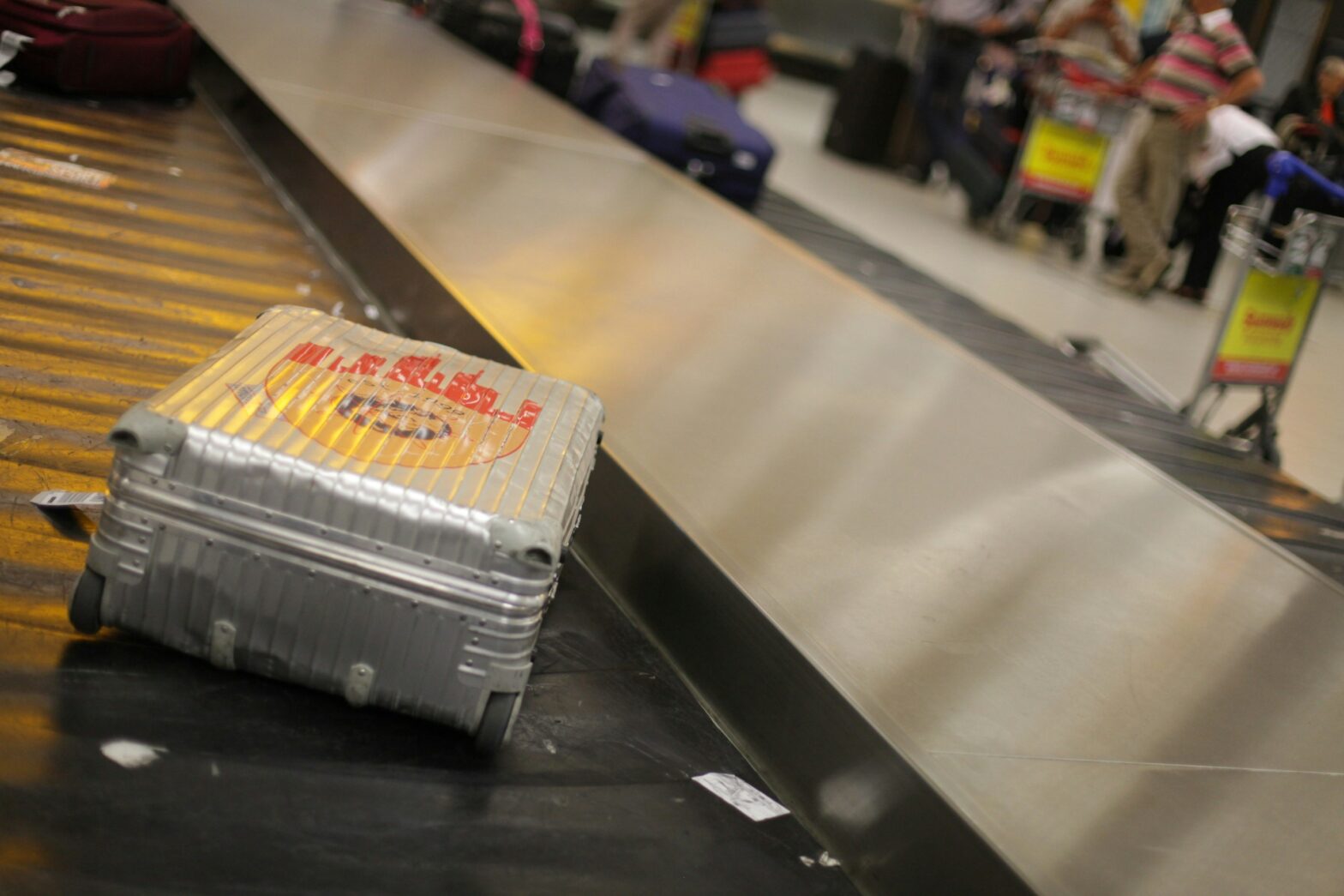 Silver suitcase in baggage claim.