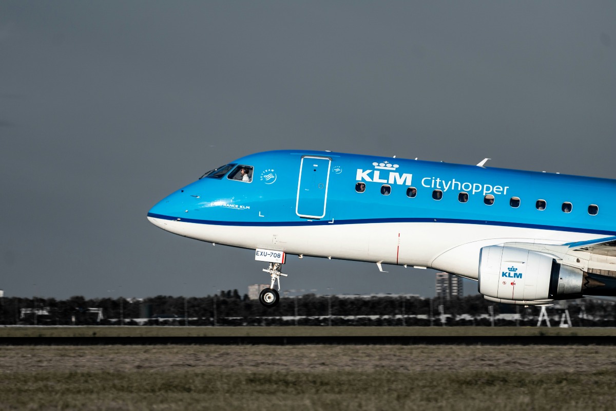 A blue and white KLM airplane on the runway.