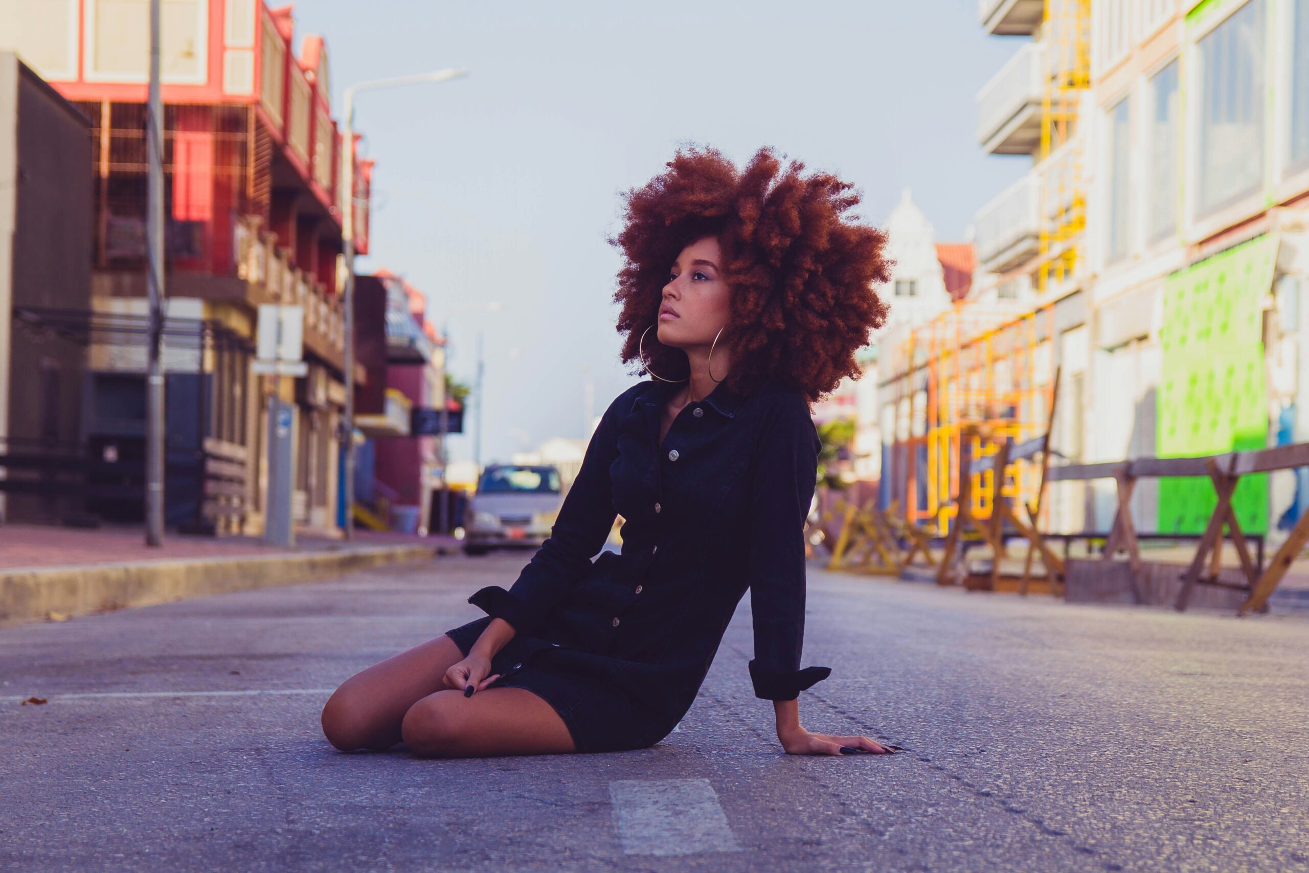 Here is what travelers should know about a trip to Aruba. 
pictured: multicultural woman in the streets of Aruba