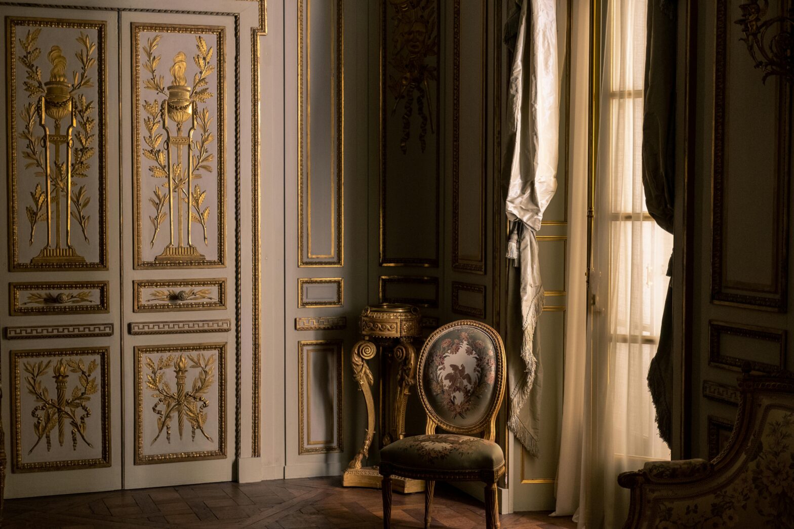 Luxury room with shadows on the wall and a chair in the corner.