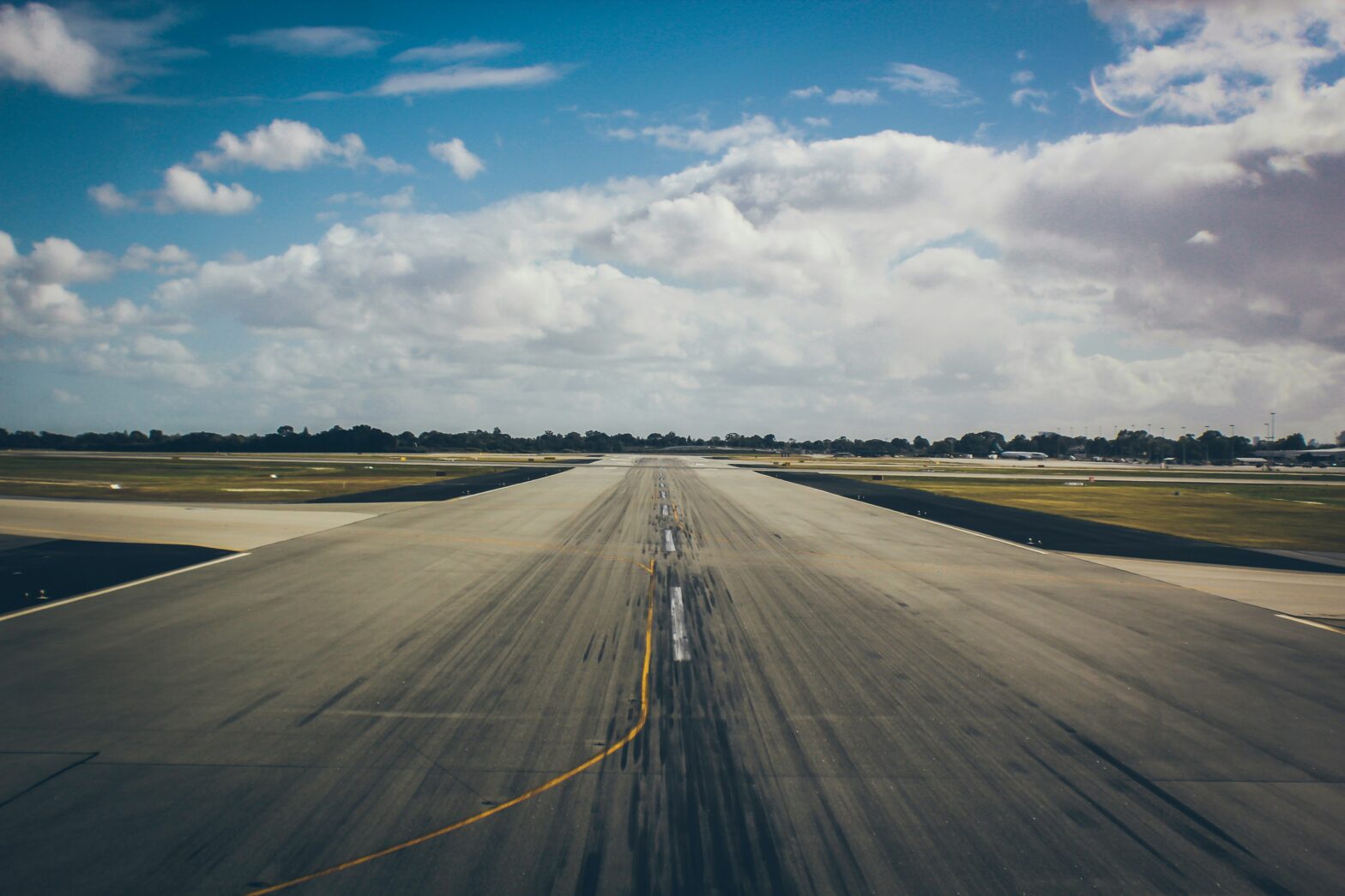 An airport runway with tire marks from planes.