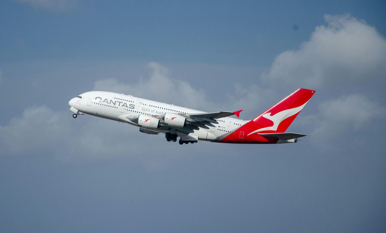 A Qantas aircraft mid air on a cloudy day.