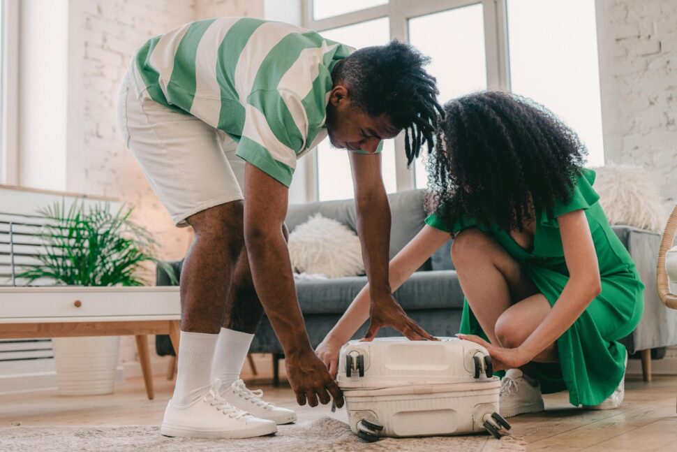 A Couple Closing a Luggage Bag