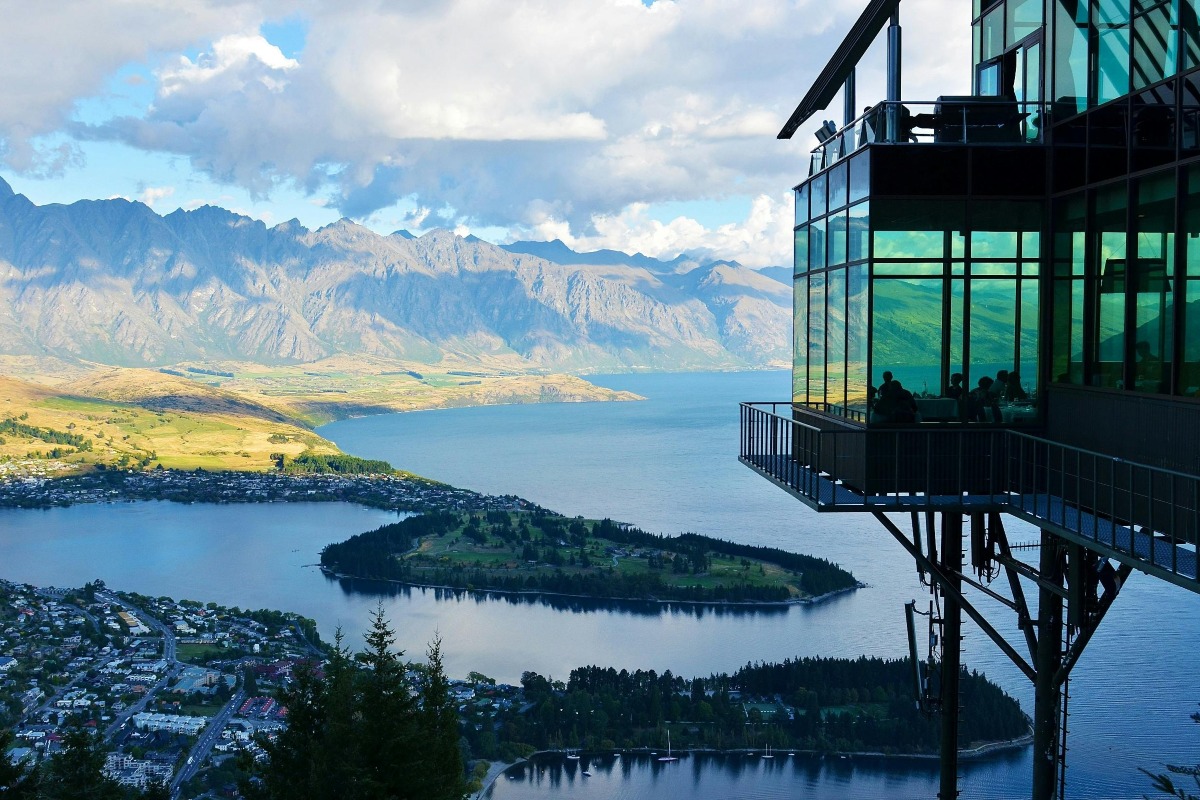 Aerial photography of Island with a glass apartment on the side.