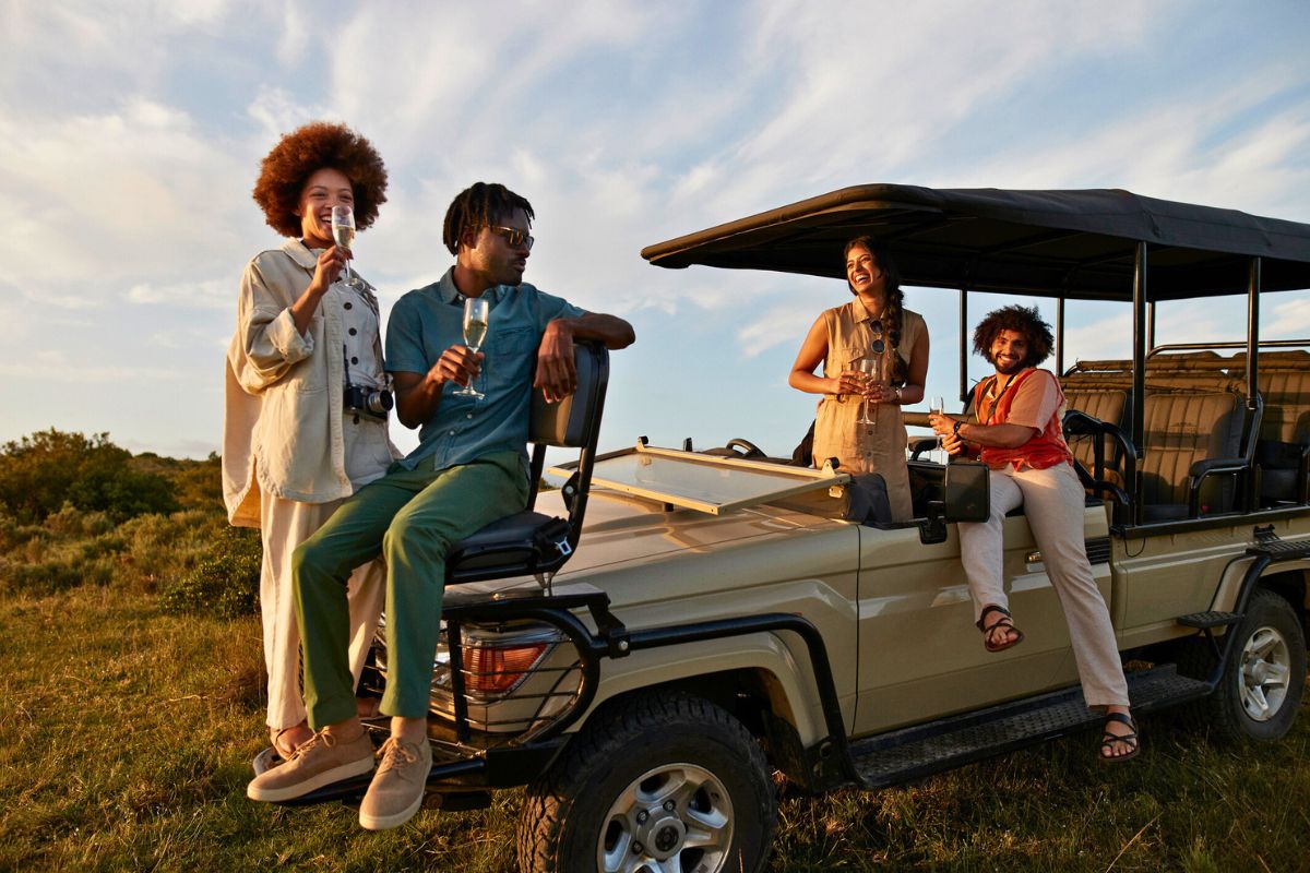 two couples on safari truck at sunset