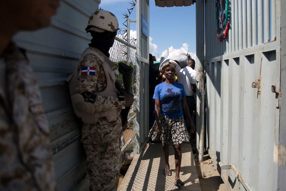 Haitian citizens cross the gate at the Dominican Republic-Haiti border