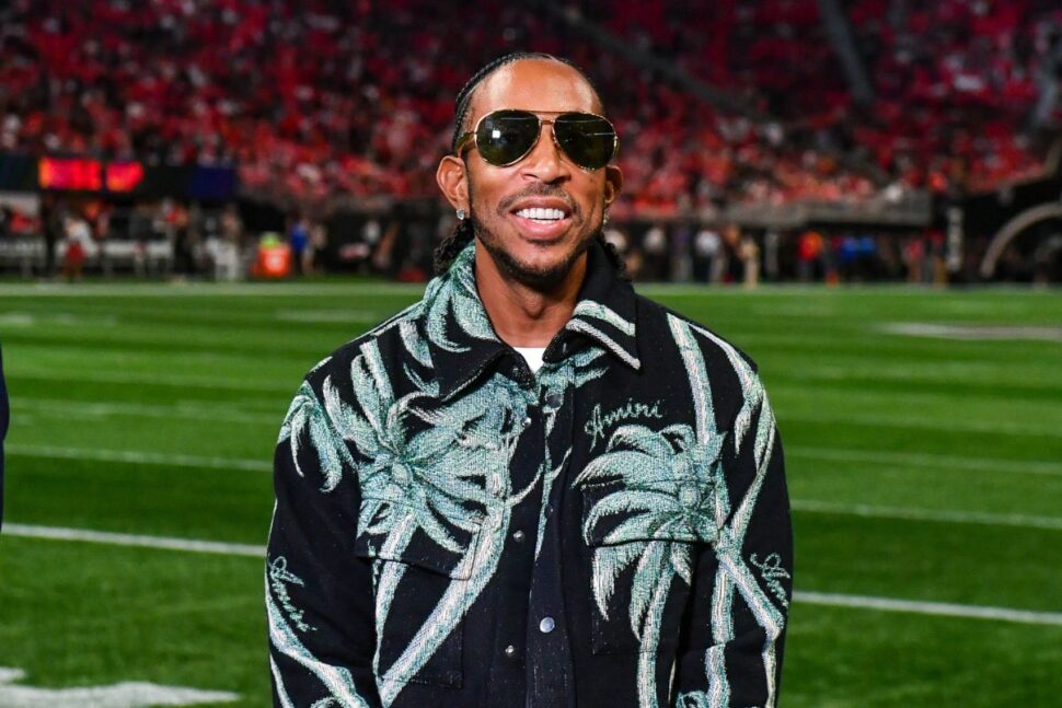 Ludacris smiling while standing on football field