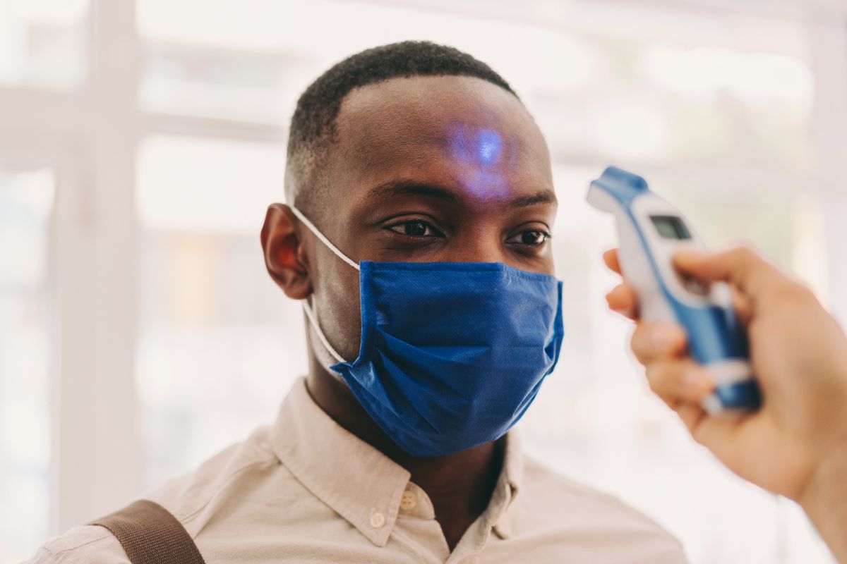 man getting his temperature checked with mask on