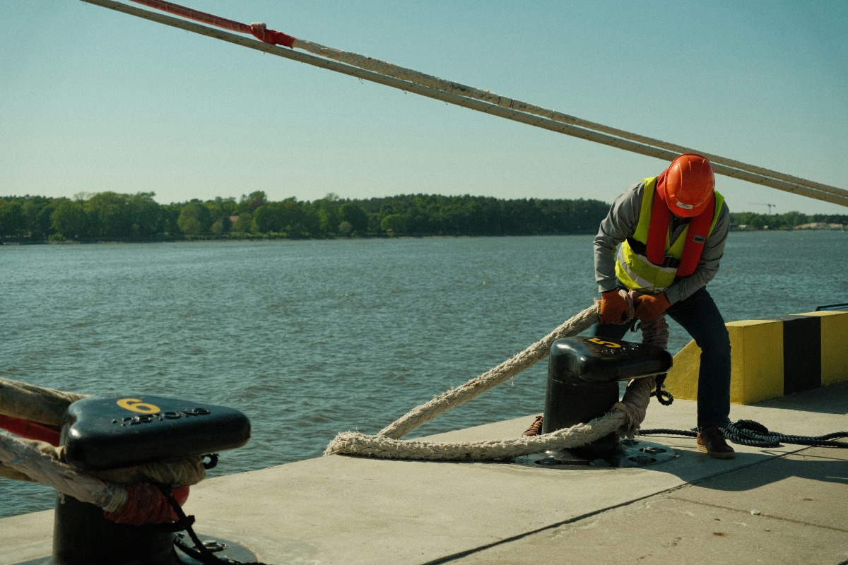 Man working on a port, helping dock a ship.