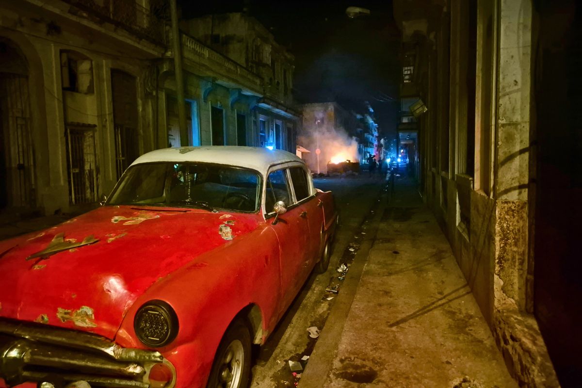 old school red car on dark street during power outage in Cuba