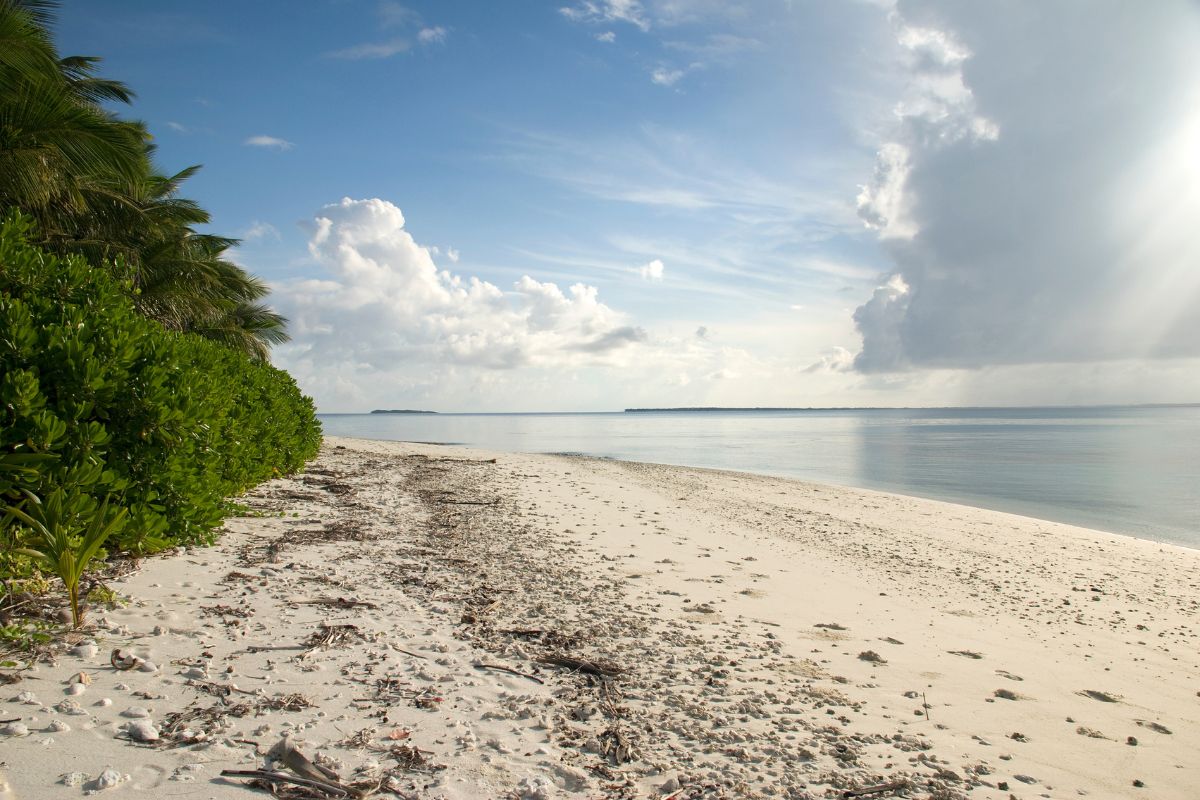 sand shoreline with clouds in the distance on Diego Garcia, Chagos Islands