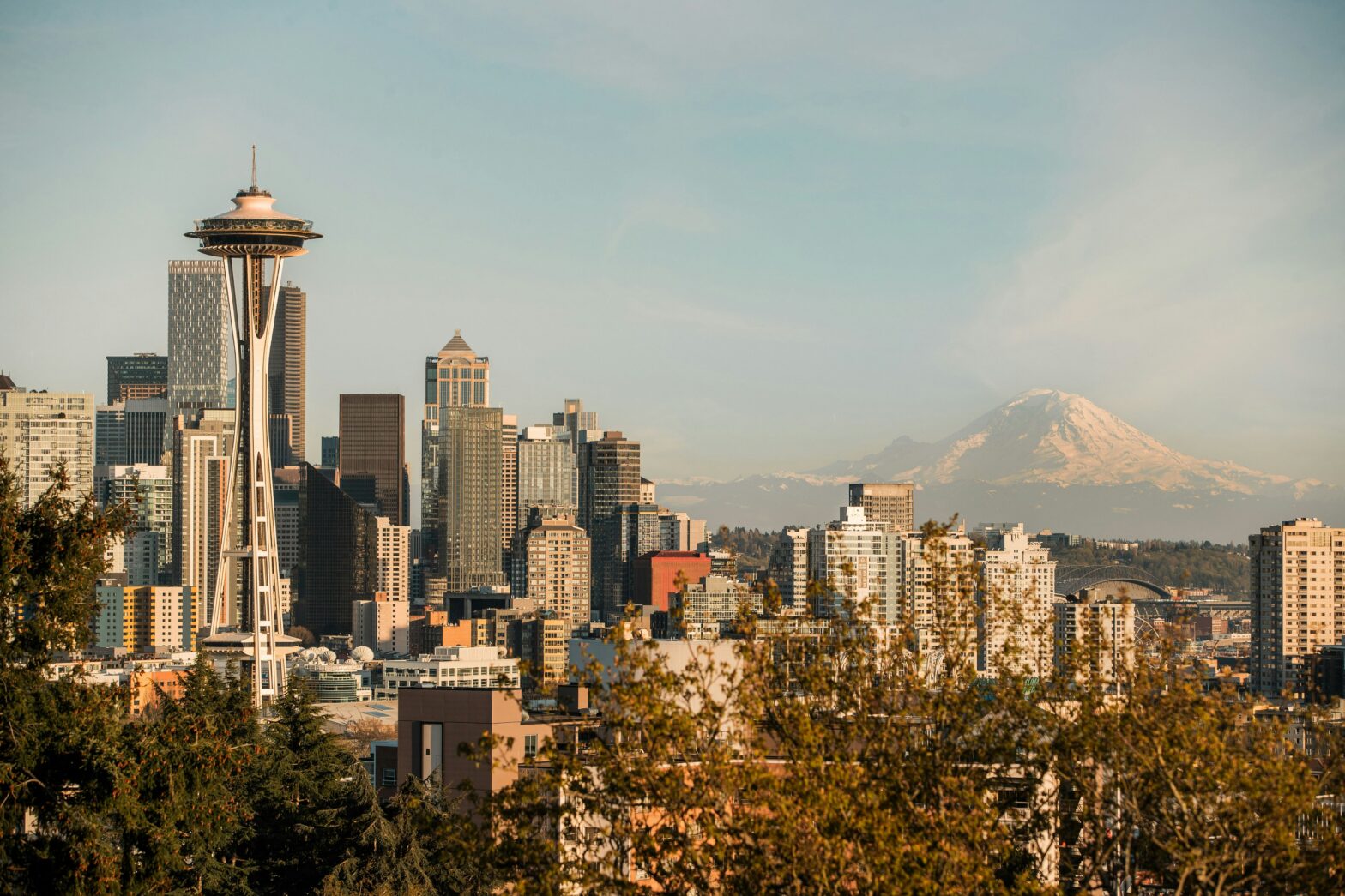 sunset view of the Space Needle and the city of Seattle with mountain in the background