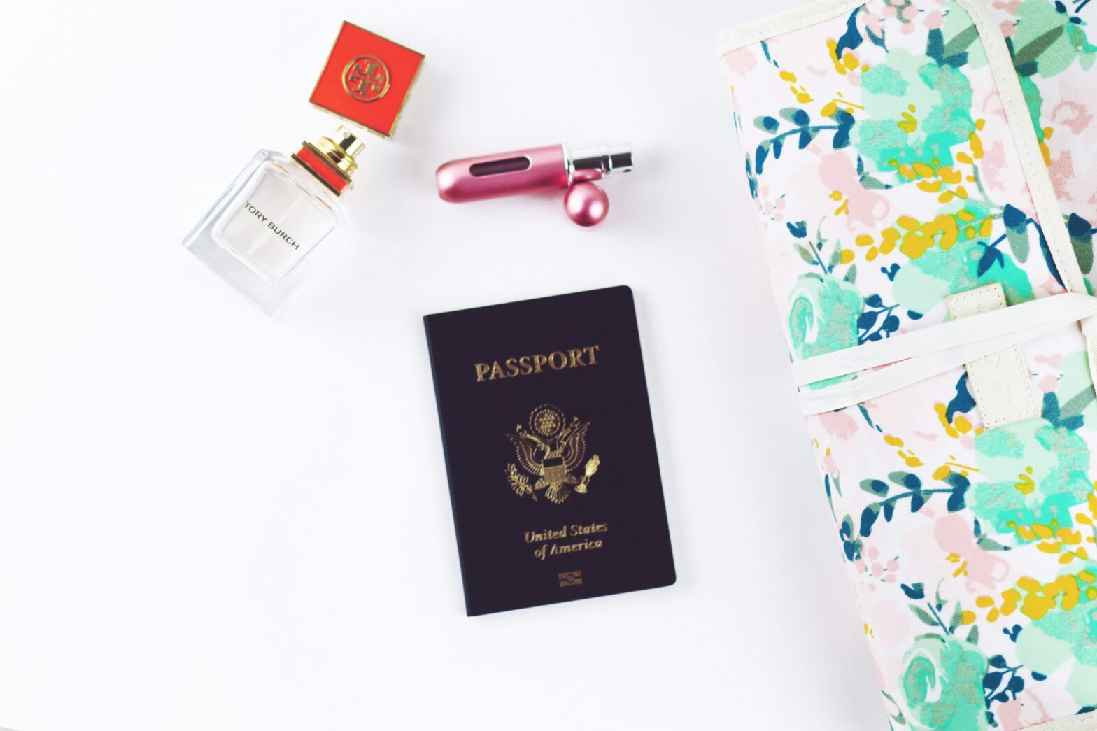 A passport and other airport accessories laying on a white table.