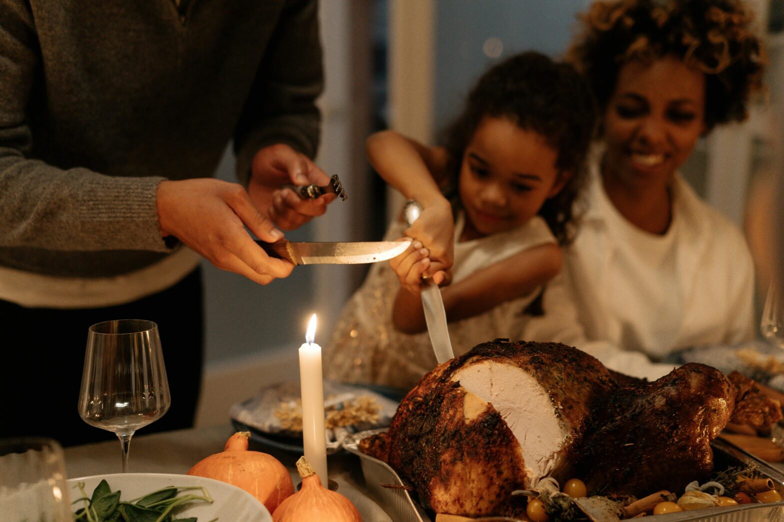 A Black family enjoying Thanksgiving dinner, craving the turkey.