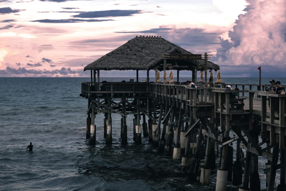 a view of the ocean with a boardwalk at sunset 