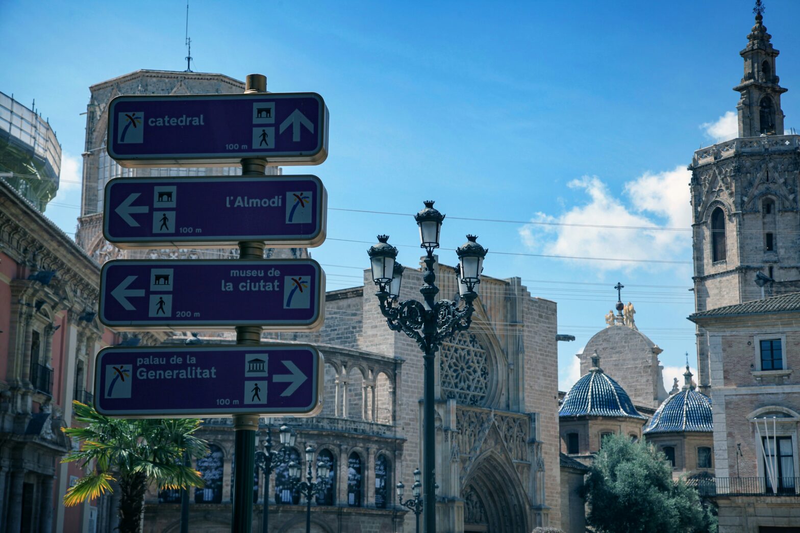 A street sign pointing out various things to do in Valencia, Spain, including directions to the cathedral, museum, and more.