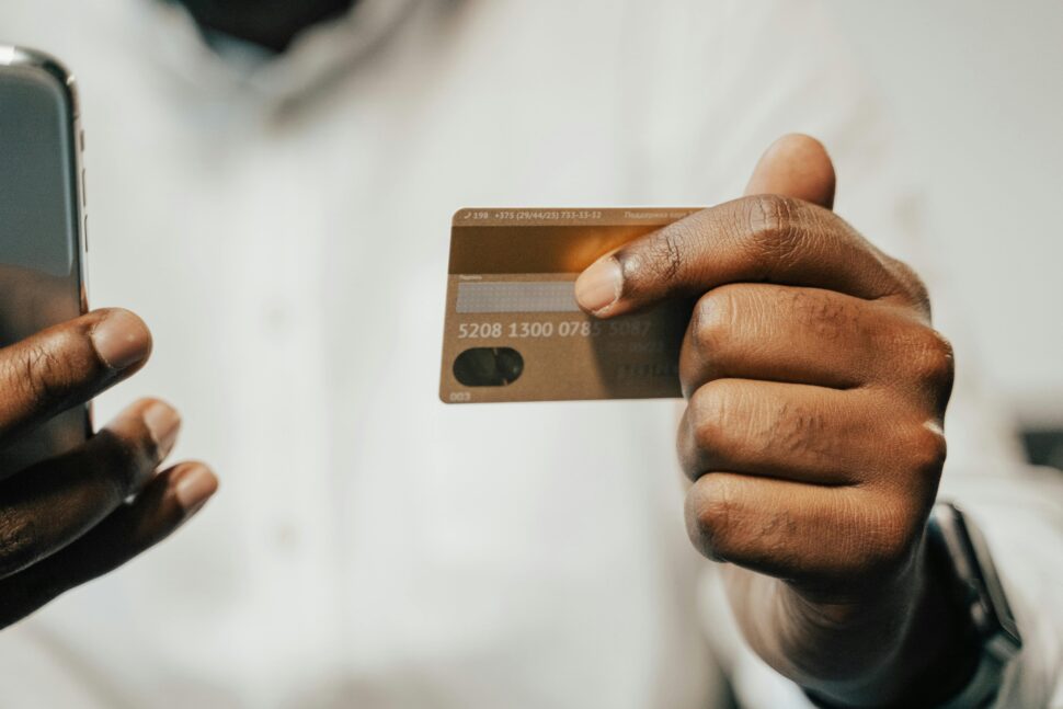 Black man holding phone and credit card