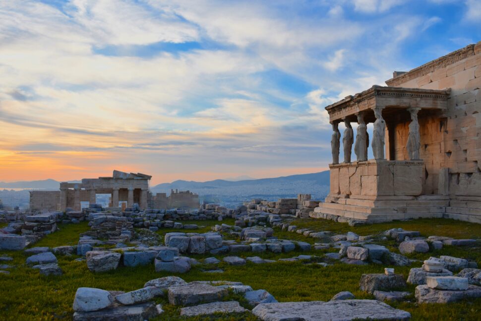 Ancient Greek ruins against a setting sun