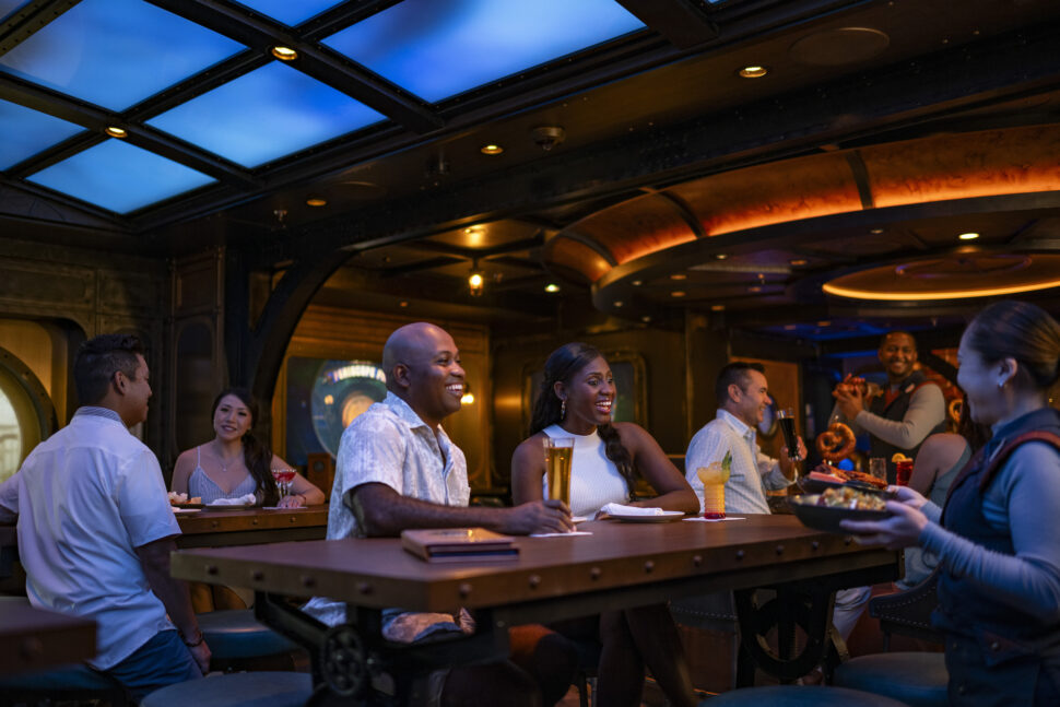 On board the Disney Treasure, a Black family enjoys Periscope Pub.