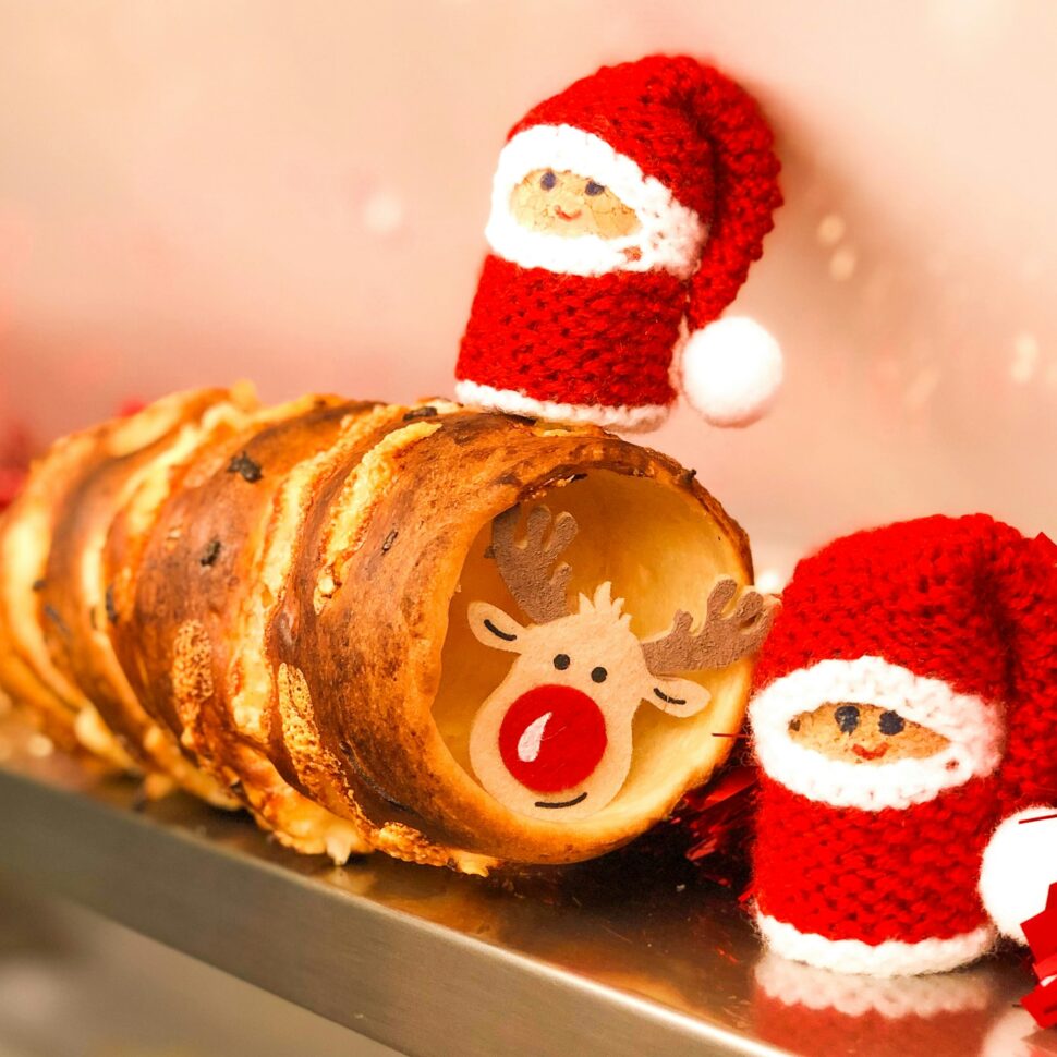 Trdelnik fried dough with two Santa Claus decorations around it