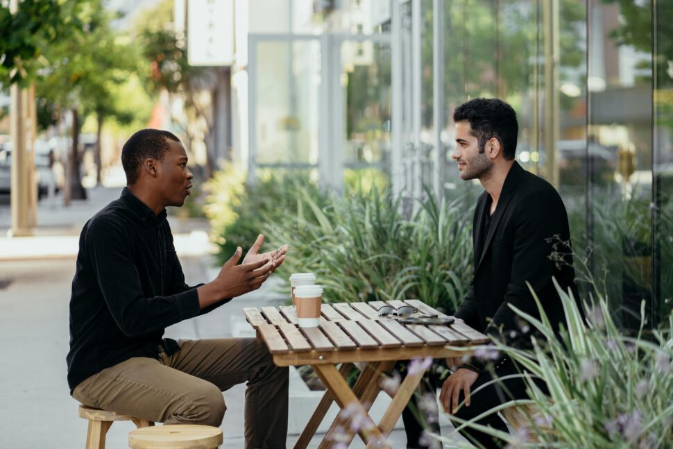 Two men speaking over coffee