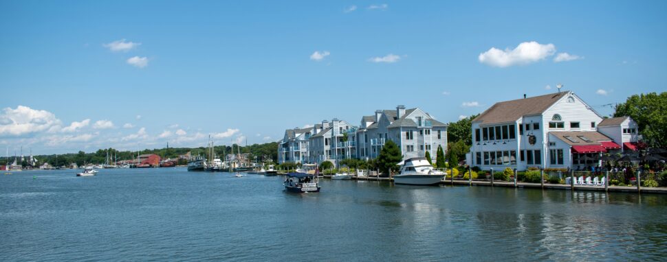 A view of Mystic Seaport, showcasing historic ships docked along a quaint, preserved maritime village.