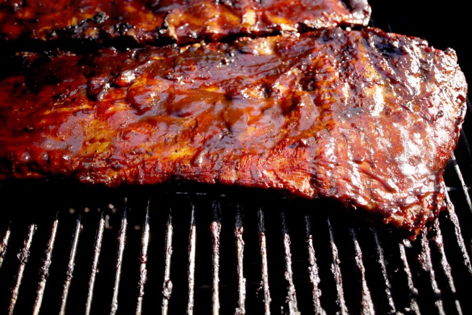 Marinated ribs cooking on charcoal grill.