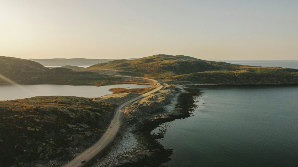 Road stretching into the distance with bodies of water on either side.