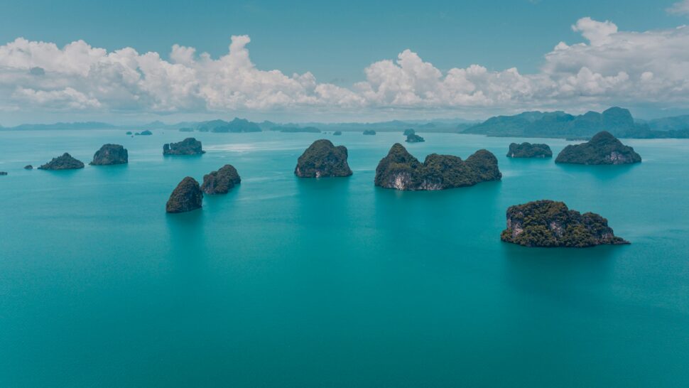 A tranquil ocean with crystal-clear waters, dotted with small, uninhabited islands.