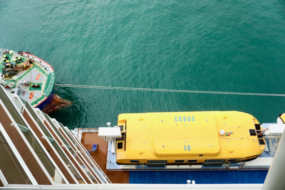 A top-down view of a family-friendly cruise ship showcasing a spacious deck with swimming pools, colorful slides, and activity areas, surrounded by the open sea, perfect for fun and relaxation for all ages.