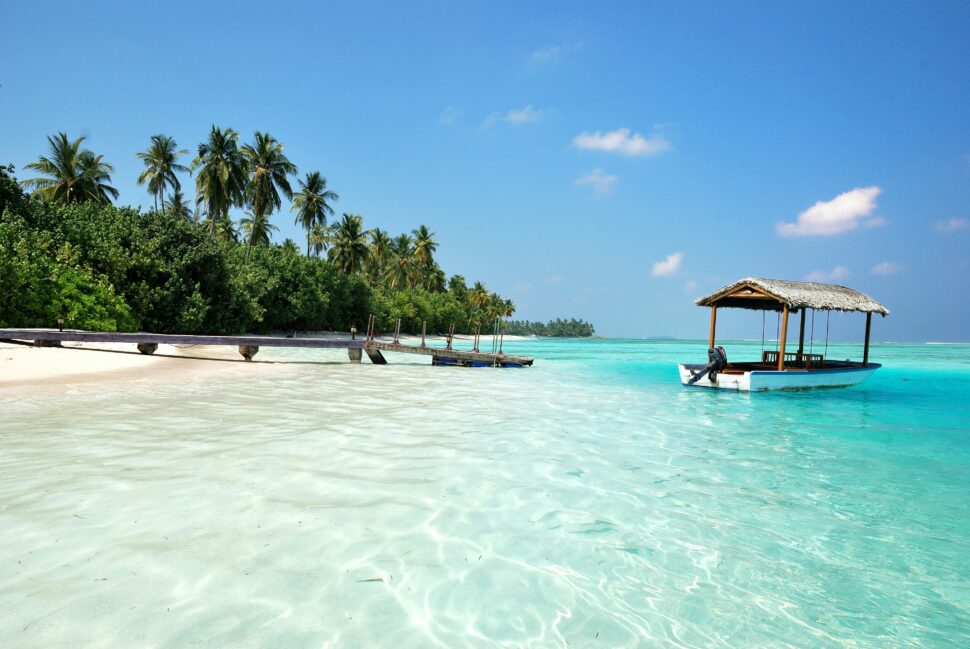 The Maldives with coast and a floating boat.