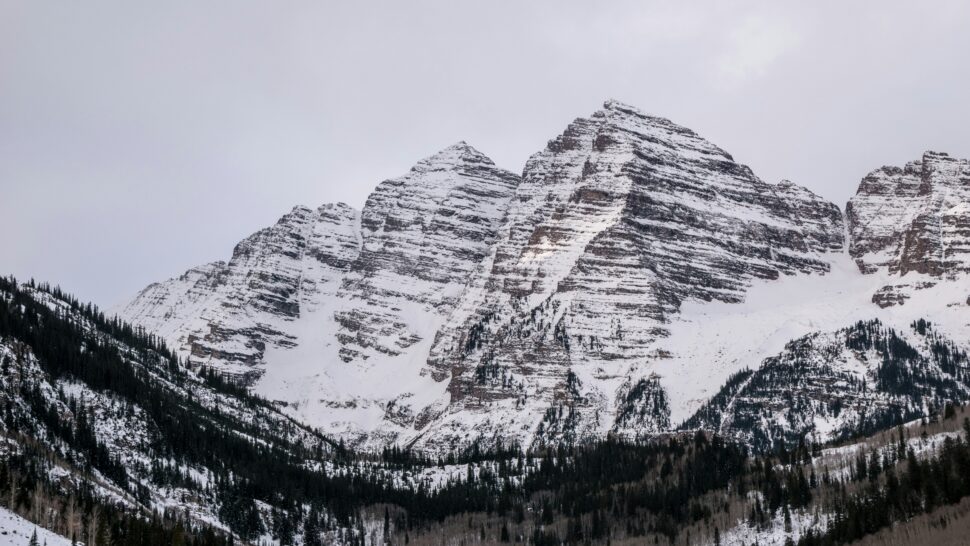 Snow-capped mountain amidst winter foliage during February for a winter wonderful destination.