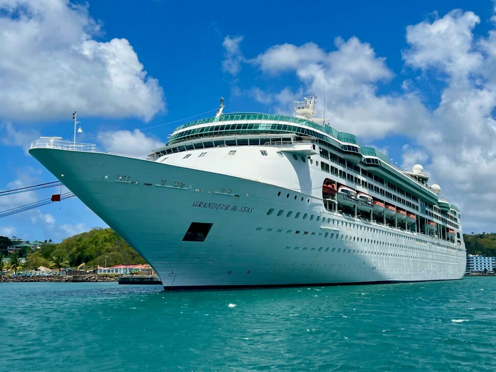 Royal Caribbean cruise ship with a lush island in the background.