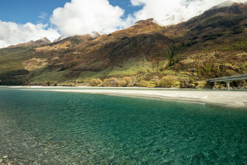 New Zealand river, with mountains and forests surrounding the area.