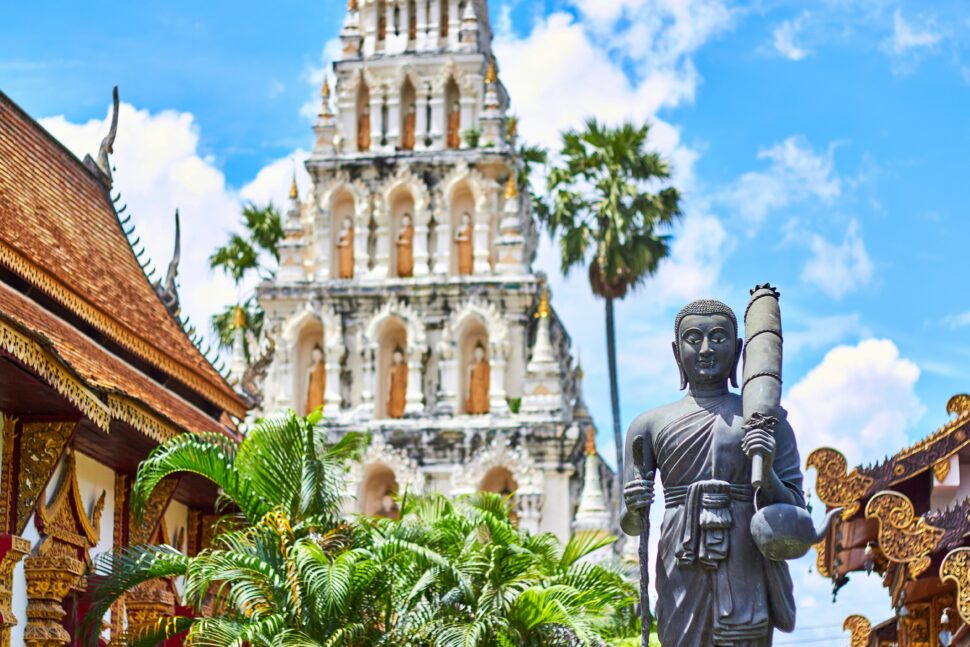 Sculpture at Wiang Kum Kan in Tha Wang Tan, showcasing intricate carvings and historical artistry set against a serene outdoor backdrop with temple.