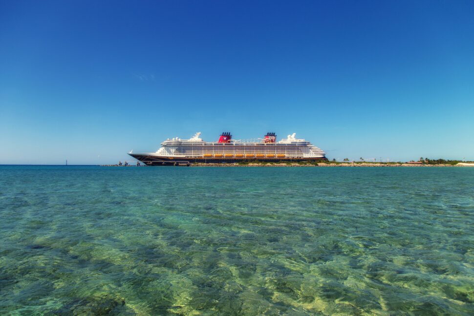 A peaceful scene of a cruise ship anchored near a secluded tropical island.