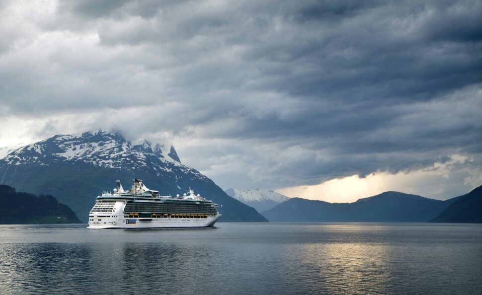 Distant view of a cruise ship sailing under an overcast sky.