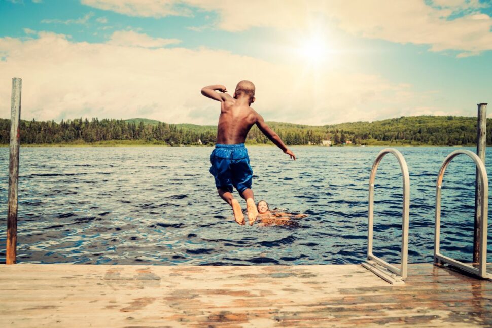 boy jumping into pier