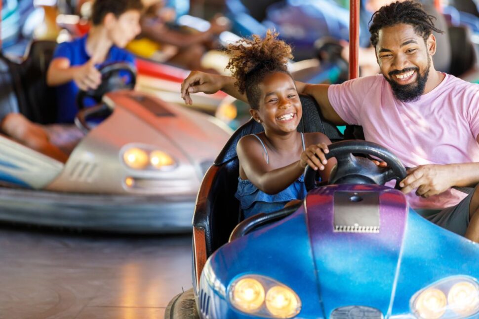 father and daughter playing bumper cars