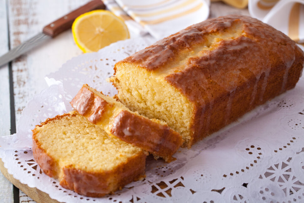 Lemon cake with lemon glaze on white wooden table