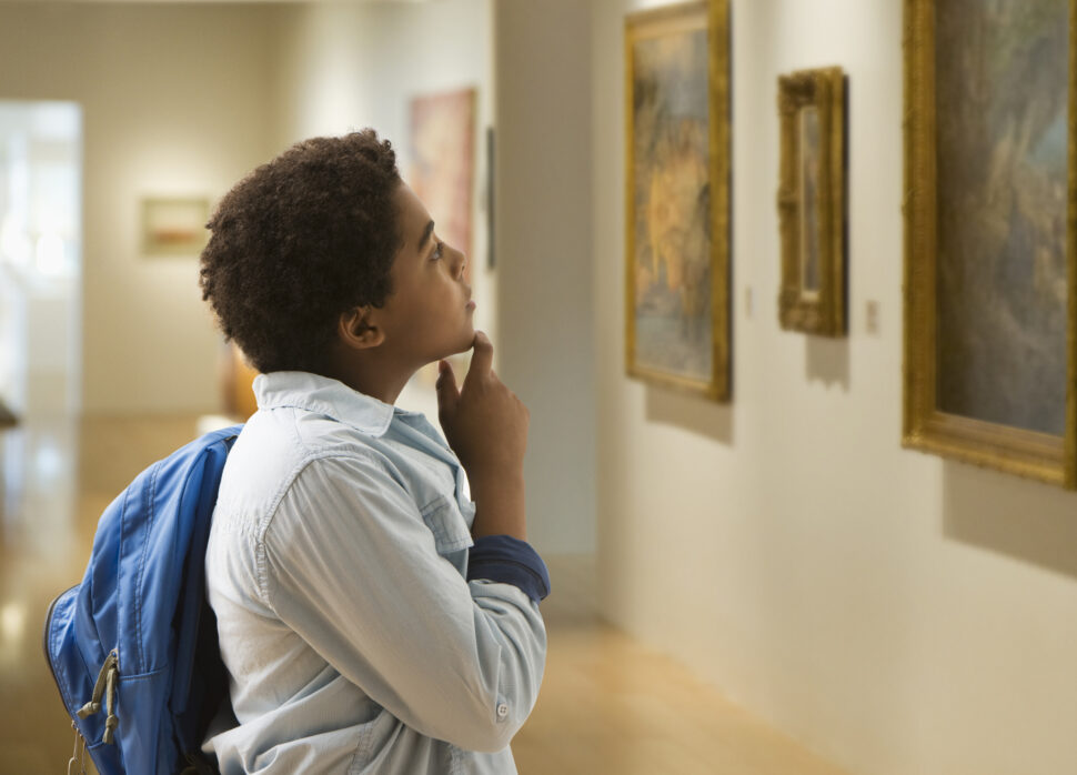 African American boy looking at painting in museum