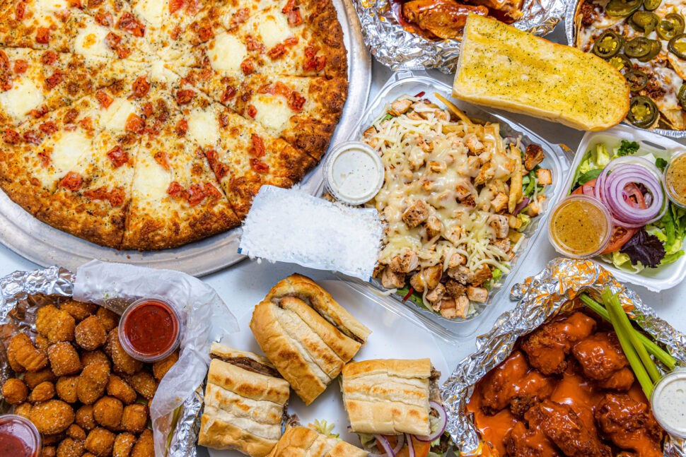 Pizza alongside a variety of food items.