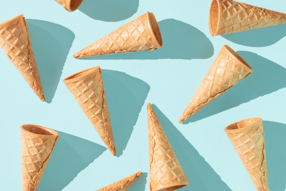 Empty waffle cones brightly lit on light blue background.