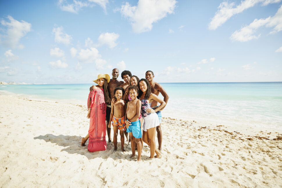 Wide shot portrait of family on tropical beach during vacation