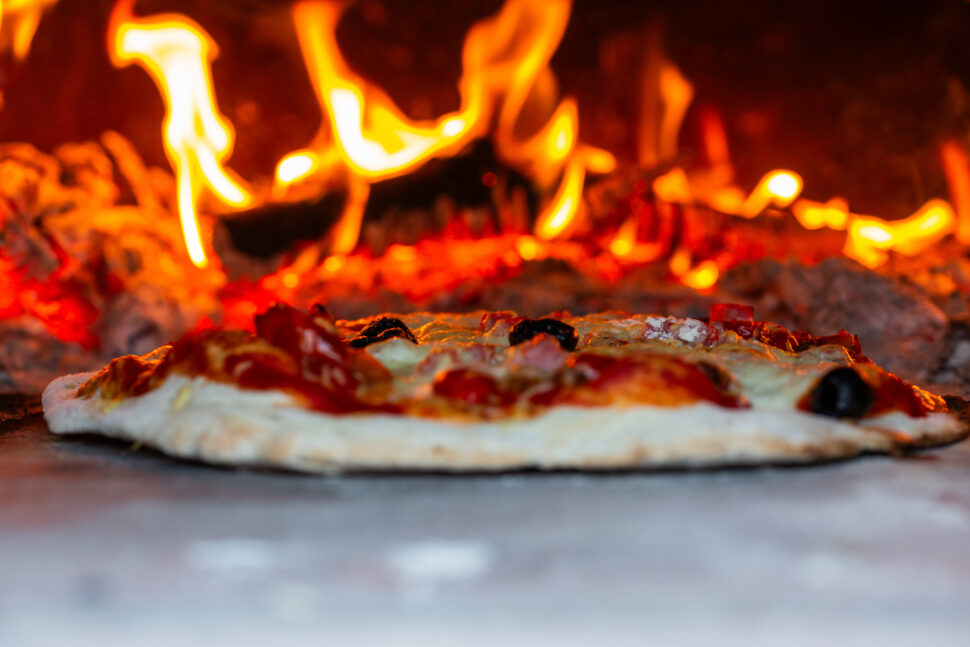 Pizza going into a stove.